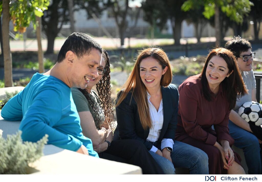 Il-Ministru Julia Farrugia i l-Ministru Miriam Dalli bilqeda ħdejn persuna b'diżabilità