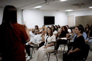 Il-parteċipanti, inkluż il-Ministru Julia Farrugia, il-Kap Eżekuttiv Oliver Scicluna, jagħmlu s-sinjal kif qed turihom Ms Xuereb