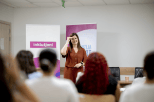 Ms Xuereb tidher fl-isfond tal-klassi, tagħmel is-sinjali, bil-lingwa tas-sinjali