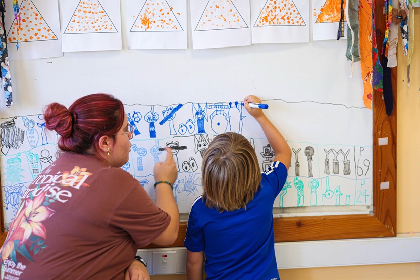 Tifel ipinġi fuq white board, ħdejn professjonista.